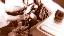 Closeup of driver's hands on steering wheel in truck cab