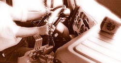 Closeup of driver's hands on steering wheel in truck cab Closeup of driver's hands on steering wheel in truck cab