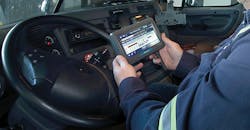Closeup of driver holding ELD in cab of truck Closeup of driver holding ELD in cab of truck