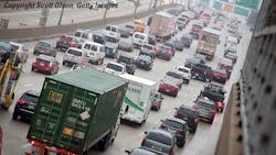 Freeway congestion from overhead taillights commercial truck in foreground Freeway congestion from overhead taillights commercial truck in foreground