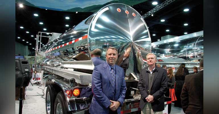 Randall Swift president of Heil Trailer International and Zack Coley vicepresident of sales and marketing stood with the 5000 gallon stainless steel DOT407 trailer displayed a MATS