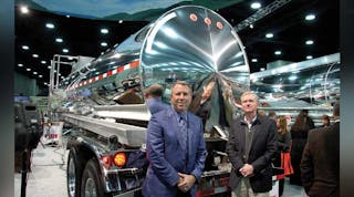 Randall Swift, president of Heil Trailer International, and Zack Coley, vice-president of sales and marketing stood with the 5,000 gallon stainless steel DOT407 trailer displayed a MATS.