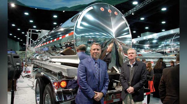 Randall Swift, president of Heil Trailer International, and Zack Coley, vice-president of sales and marketing stood with the 5,000 gallon stainless steel DOT407 trailer displayed a MATS.