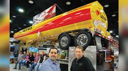 Pictured with the brightly painted show trailer at right foreground are Ed Mansell, vice-president of MAC Liquid Tank Trailers and Jim Maiorana, president. Seated at left are some of the workers at the Kent and Billings plants who attended the Mid-America Trucking Show. (sales@macltt.com)