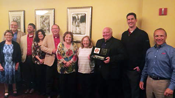 Heil Trailer presents the Werts Welding team with plaque commemorating 60th