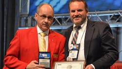 Peter Savage, right, director of quality and implementations at Clarke Power Services, accepts his Silver Spark Plug award from Ken Calhoun, TMC's chairman. Peter Savage, right, director of quality and implementations at Clarke Power Services, accepts his Silver Spark Plug award from Ken Calhoun, TMC's chairman.