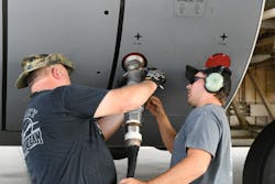 James Hatcher, 559th Aircraft Maintenance Squadron work lead, left, and Colby Bryant, 559th Aircraft Maintenance Squadron C-5 Functional Test mechanic, secure a single point receptacle connector to a C-5 Galaxy to begin defuel operations at Robins Air Force Base. SPR nozzle is the R-11&rsquo;s trucks main hose that connects to the aircraft for refueling and defueling operations.