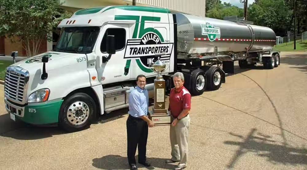 Ray Riley, at right, holds Miller Transporter&rsquo;s 2016 Heil Trophy.