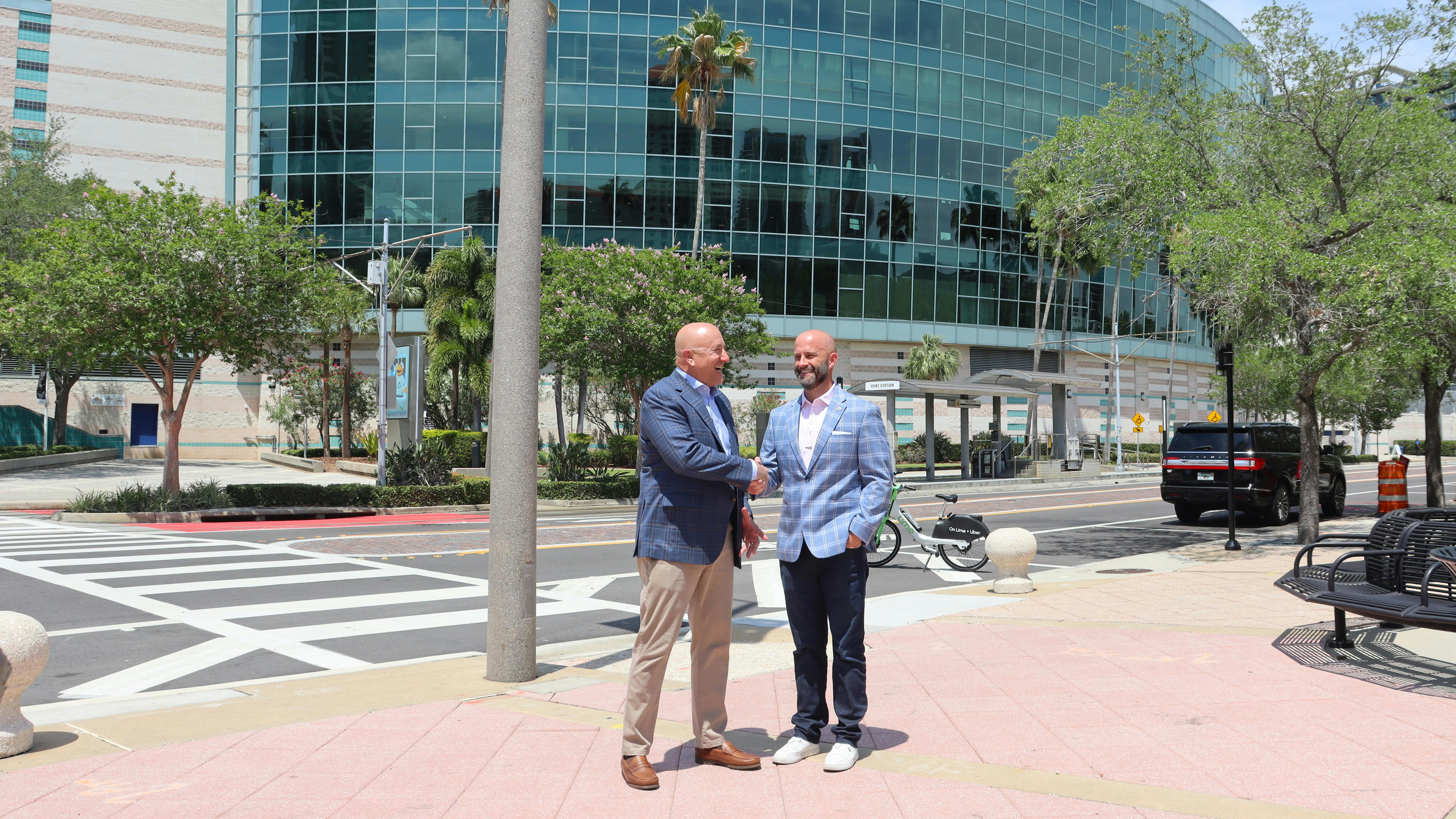Outgoing NTTC Chairman Ward Best, at left, shakes hands with new chairman David Price in front of Amalie Arena in Tampa, Florida.