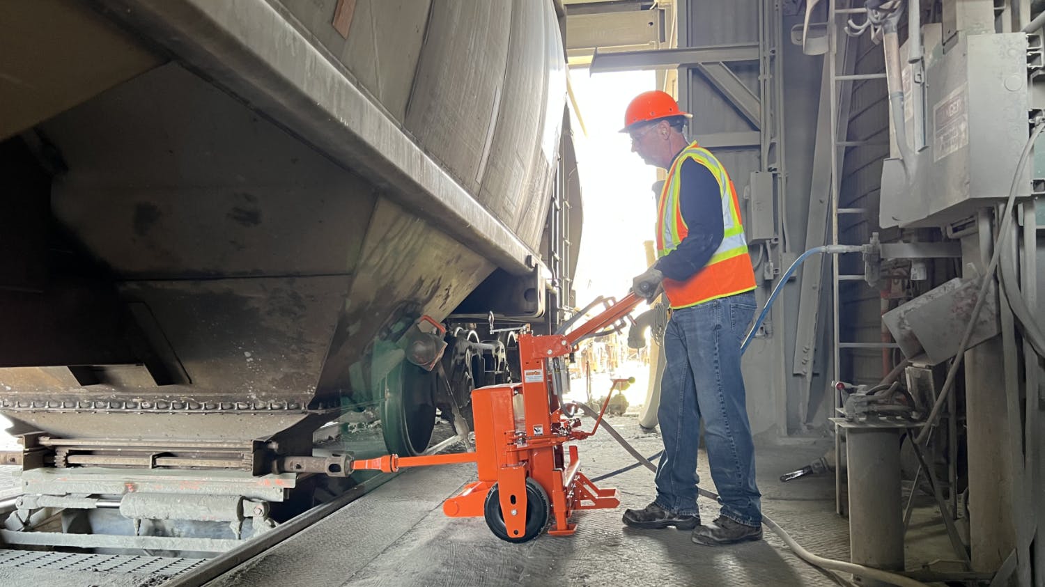 A worker inserts the bit into the capstan on a stopped hopper car to release the gate.