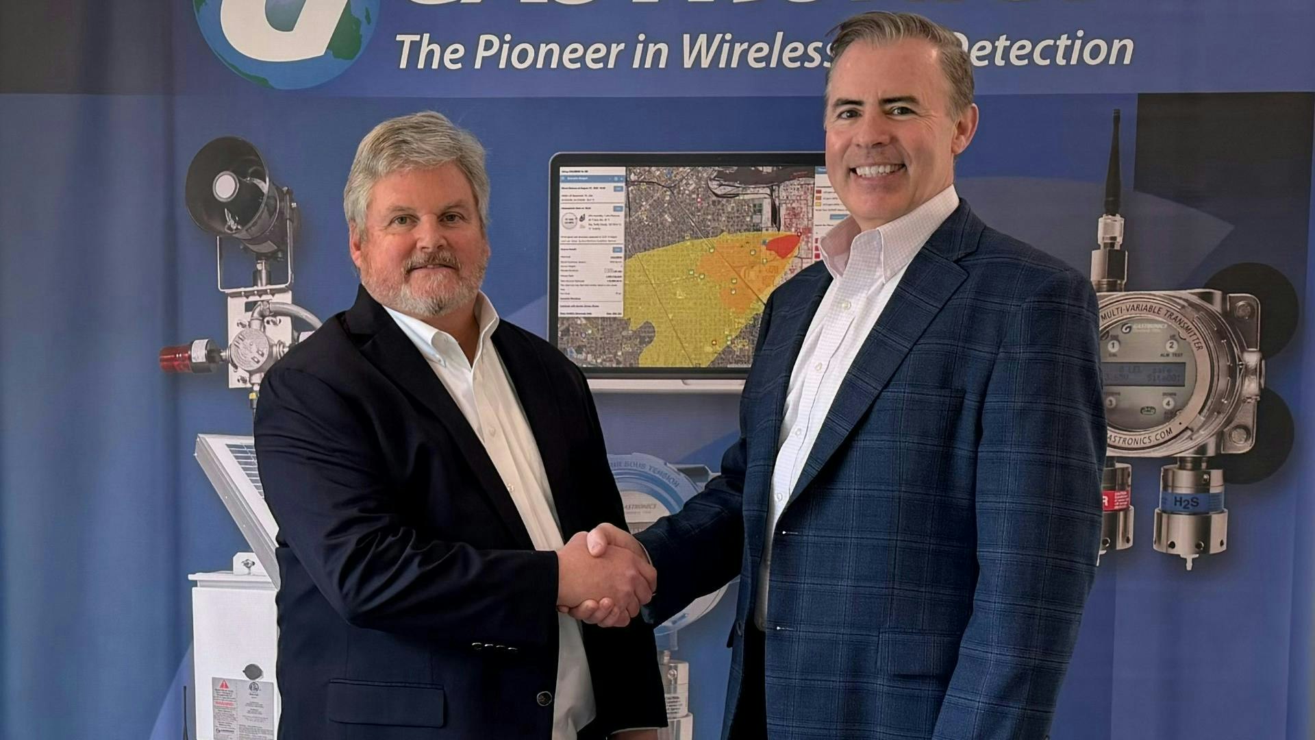 Bud Dungan, founder and CEO of Gastronics, at left, shakes hands with Kevin McKeigue, Safe Monitoring Group Americas president.