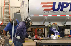 Veteran welders look on as STE’s Paige Cushing, now an inside sales rep for the tank trailer manufacturer, shows off her welding skills during a surprise visit to UPT’s terminal in Oklahoma City.