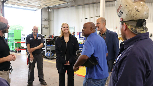 STE inside sales representative Paige Cushing (center) smiles as UPT&rsquo;s veteran maintenance crew realizes they&rsquo;ve been &ldquo;Punk&rsquo;d.&rdquo; Her surprise shop visit served as a lighthearted finale to a major milestone week for UPT, which celebrated its 60th anniversary in Oklahoma City by hosting an open house at its new downtown headquarters and showcasing custom STE tank trailers at Tank Truck Week 2026.