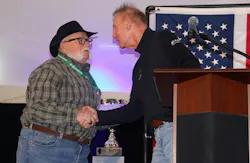 G&D/Hoffman driver Mark Hall shakes hands with company president Kevin Hoffman as he receives a $4,500 bonus for his 25 years of service and achieving nearly 5 million career safe miles.